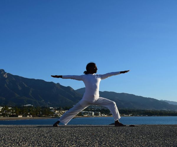 Silhouette of a man stretching against a sunrise.